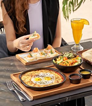 A delightful outdoor brunch featuring fresh salad, eggs, smoked salmon, and juice in Cairo, Egypt.