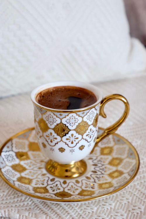 Free Ornate gold-trimmed cup with Turkish coffee on a textured surface. Elegant and classic. Stock Photo