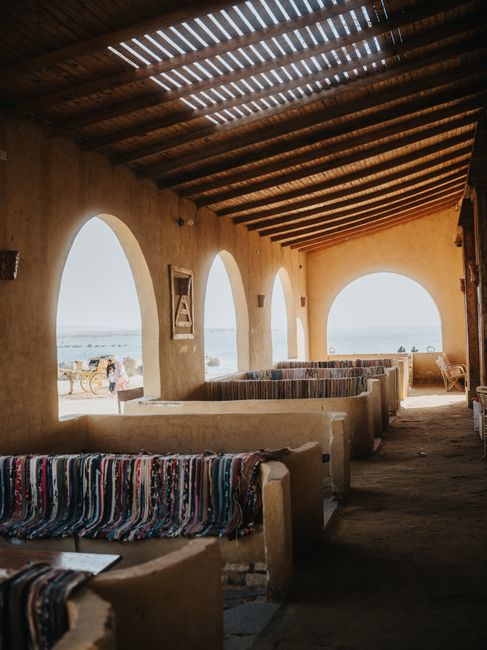 Traditional Egyptian courtyard showcasing arched architecture and vibrant woven textiles, ideal for cultural exploration.