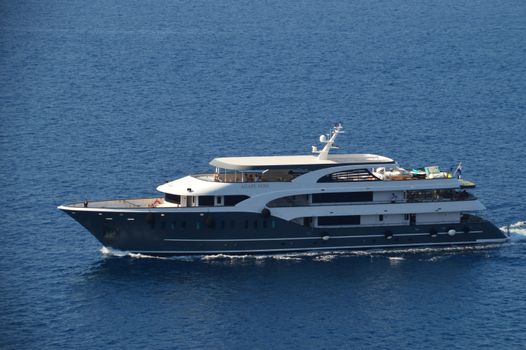 A luxury yacht sailing on calm blue waters under a clear sky, showcasing elegance and adventure.