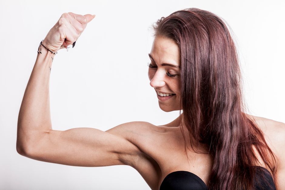 Woman identifying her biceps and triceps while holding a light dumbbell - arm toning exercises for females at home Woman identifying her biceps and triceps while holding a light dumbbell - arm toning exercises for females at home