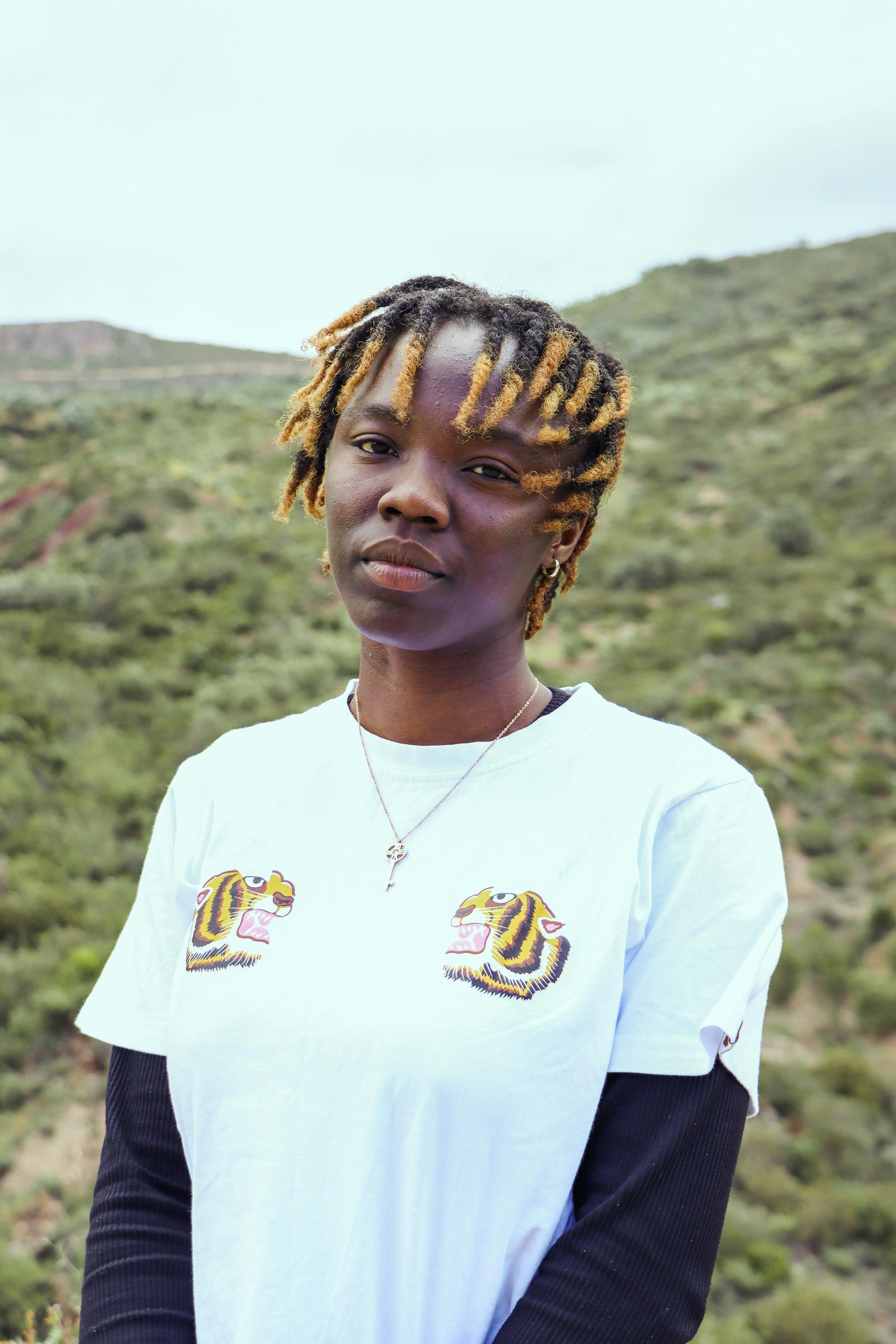 A person stands outdoors in a lush Moroccan landscape, expressing calmness.
