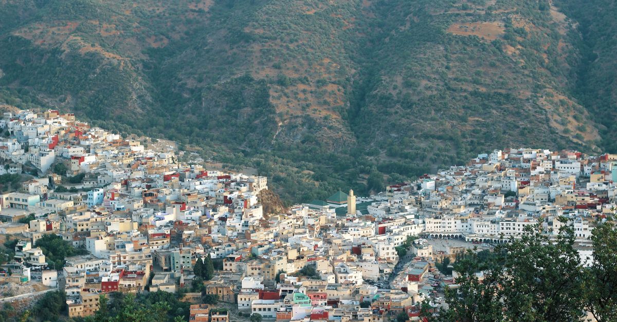 Stunning aerial view of the colorful town of Chefchaouen nestled in lush Moroccan mountains.