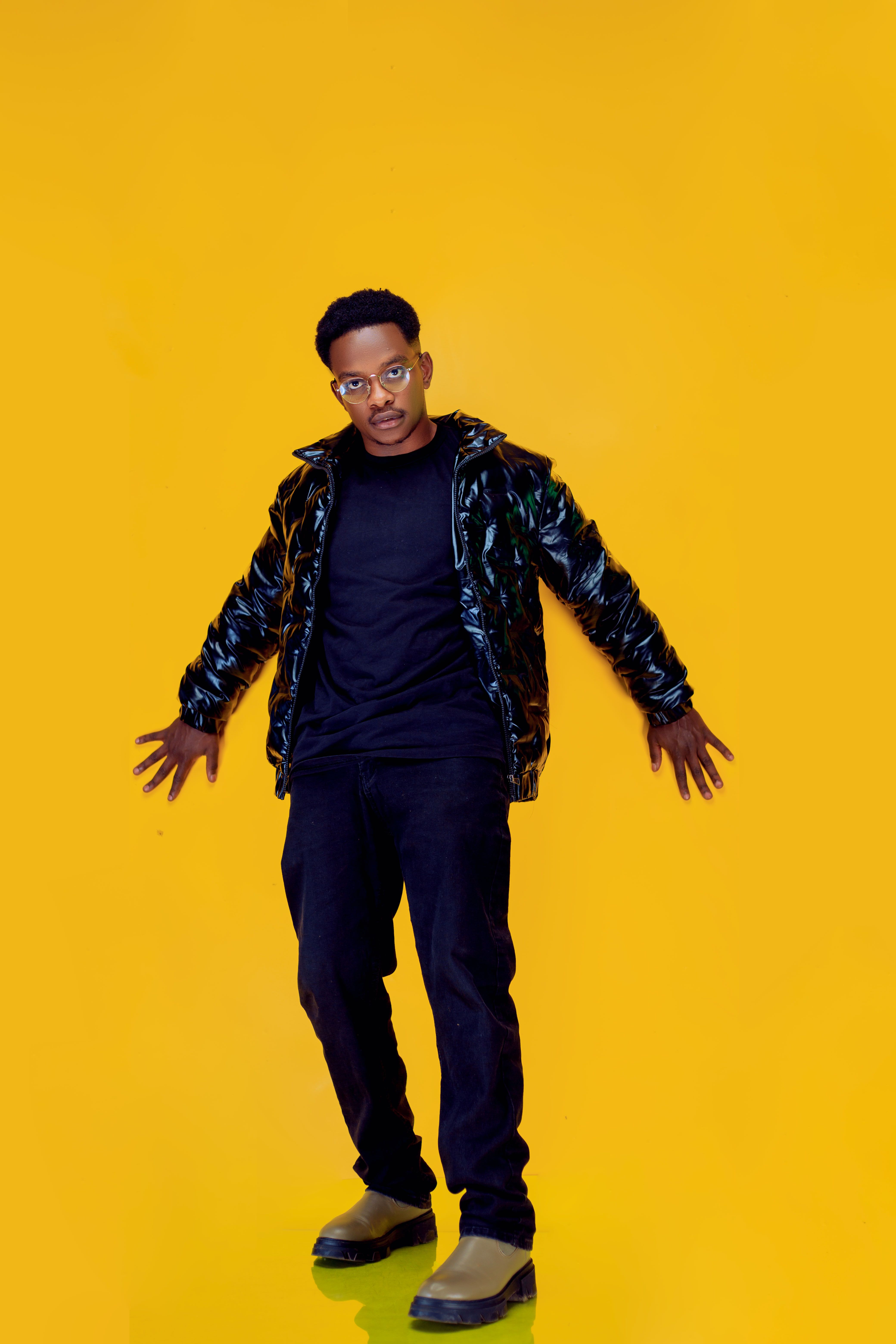 Stylish Man Posing Against Vibrant Yellow Background · Free Stock Photo