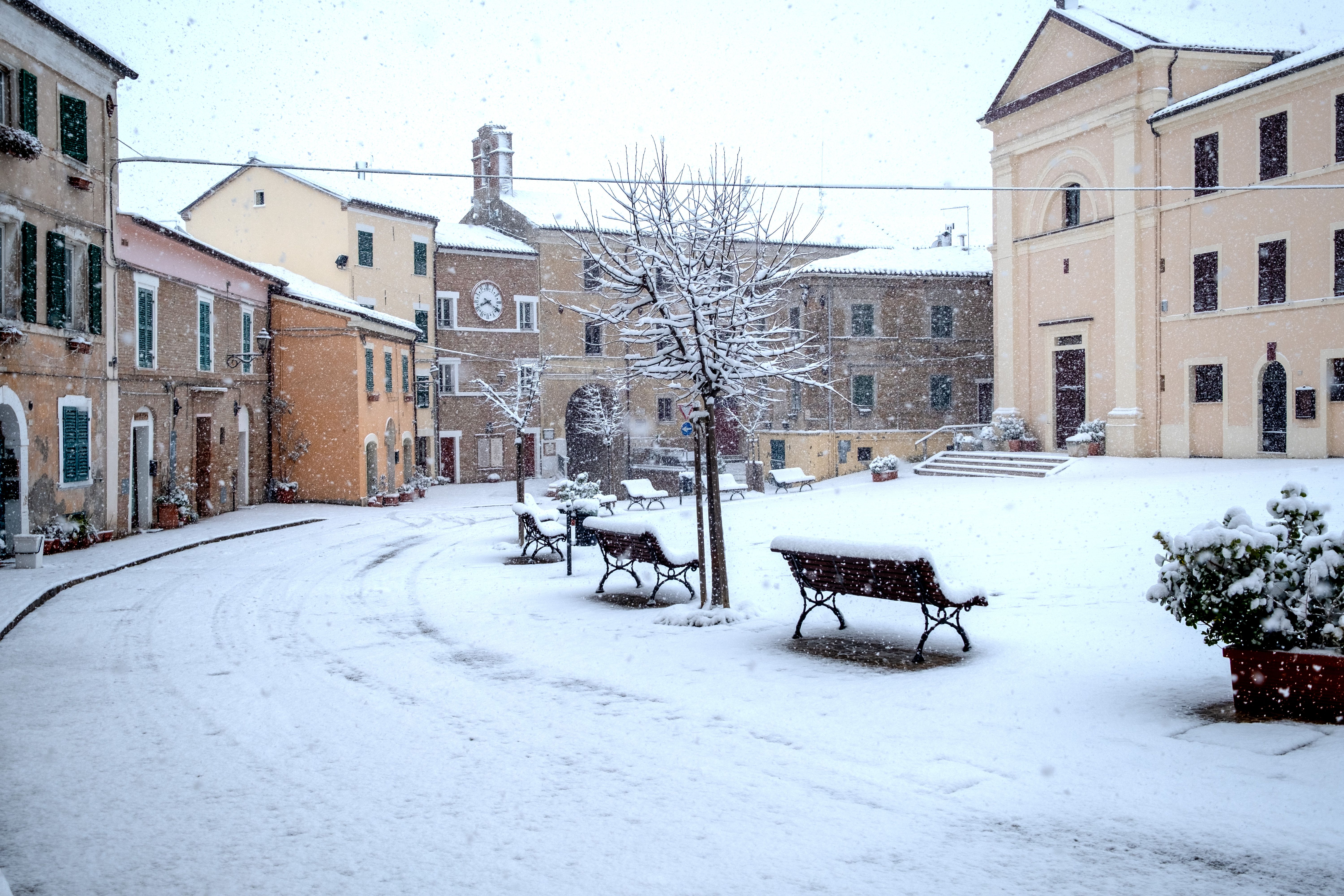 Picturesque village square covered in snow, capturing serene winter beauty.