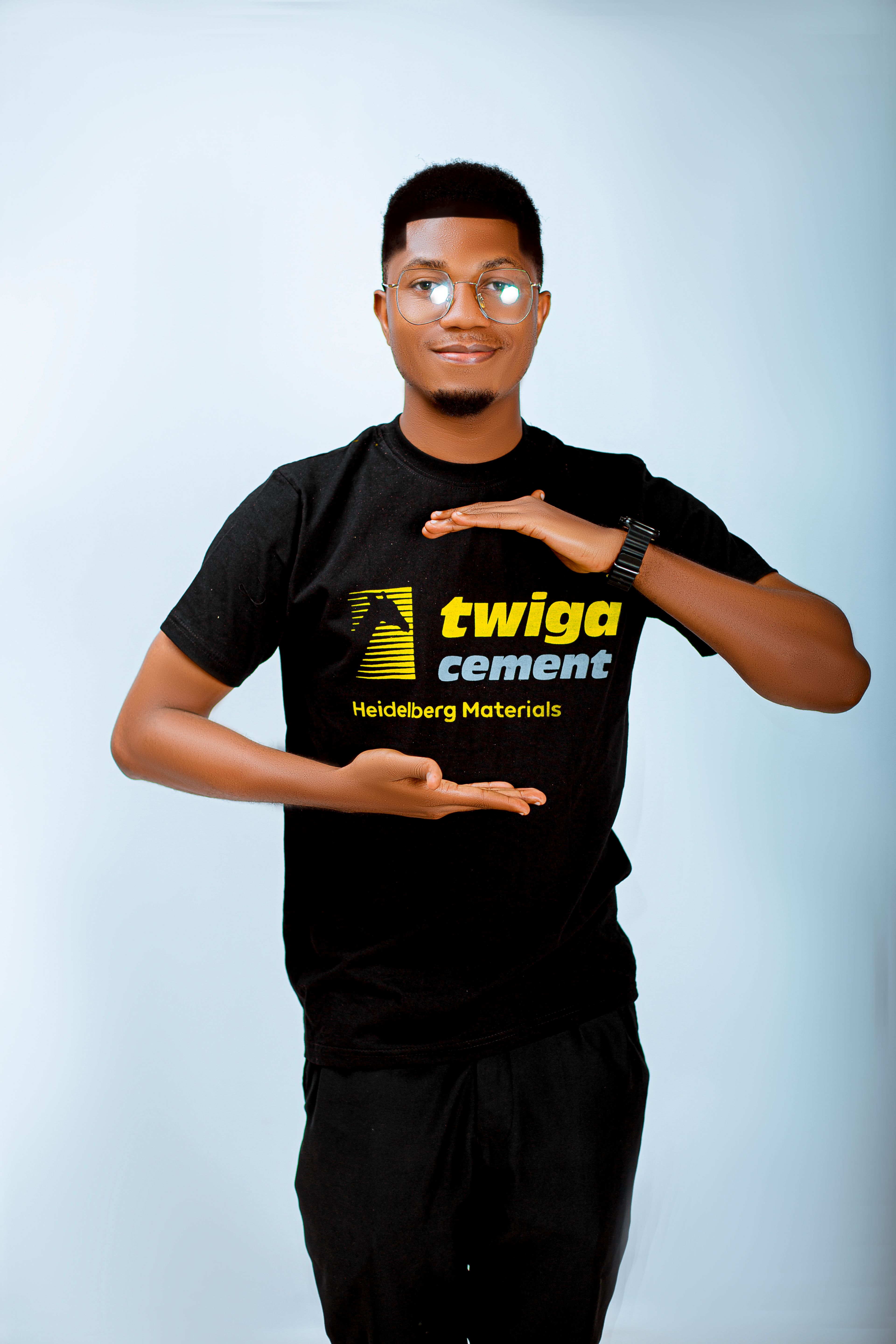 Young man in a Twiga Cement shirt posing confidently against a light background.