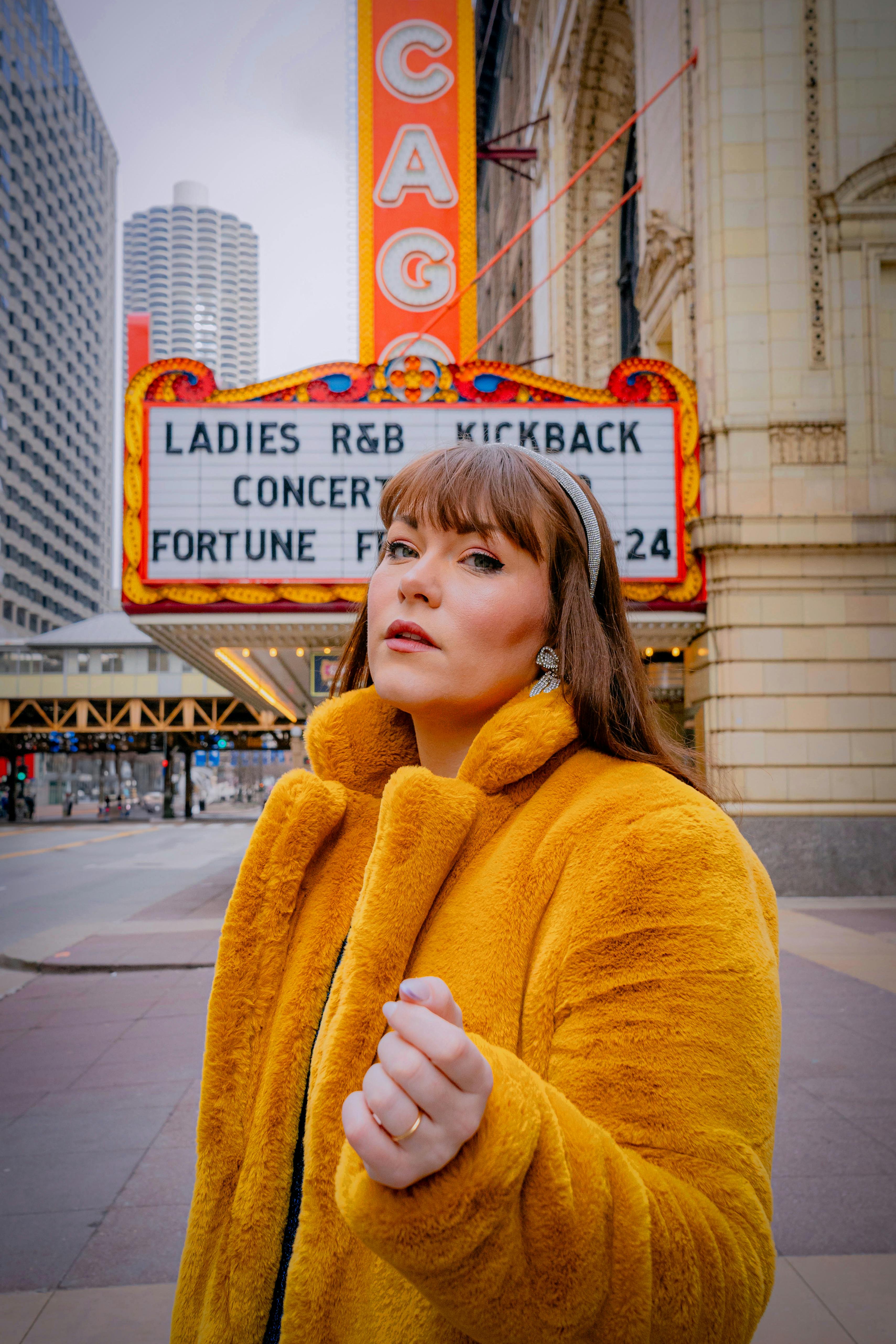 Gratuit O femeie într-o haină galbenă pozează în fața cortului teatrului din Chicago din centrul orașului. Fotografie de stoc