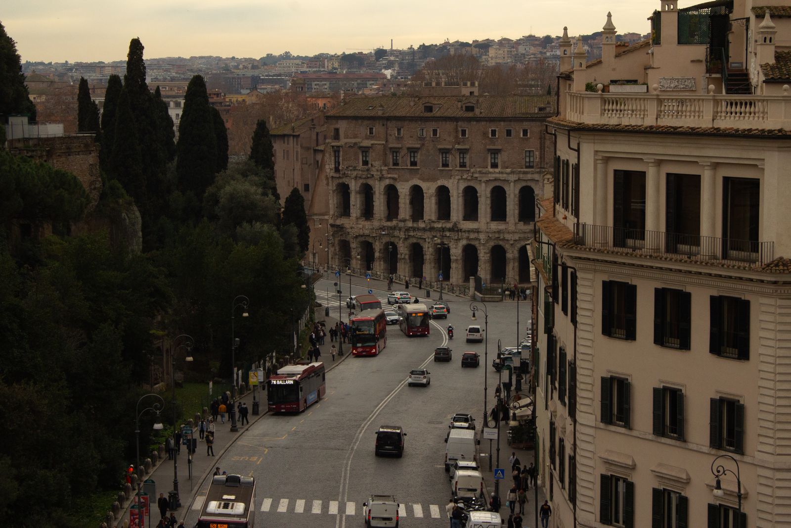 Traffic on a street in central Rome lined with historic buildings