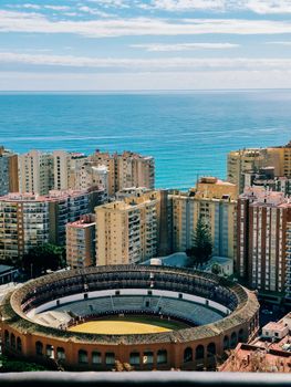 Stunning aerial view of Málaga's bullring with coastal cityscape backdrop.