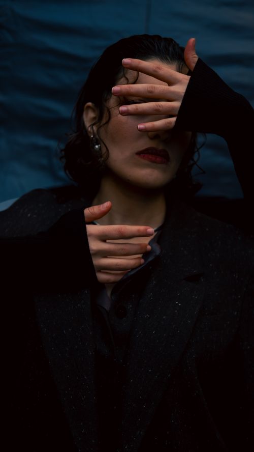 Free A moody portrait of a woman obscured by hands, evoking mystery. Stock Photo