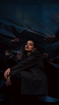 A dramatic portrait of a woman in a dimly lit setting, with artistic flair.