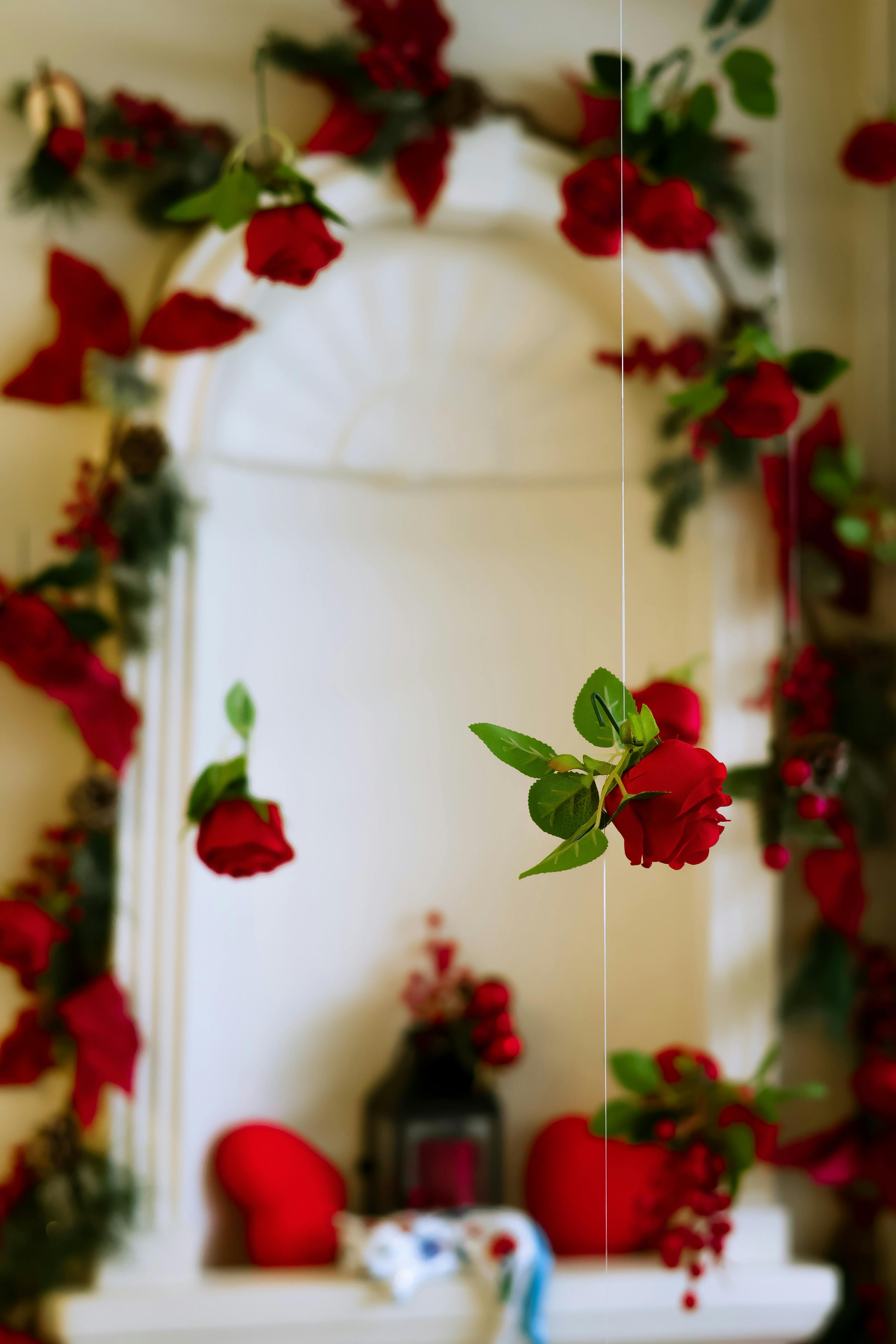 Red roses hanging in an archway with vibrant floral decor create a romantic atmosphere in Türkiye.