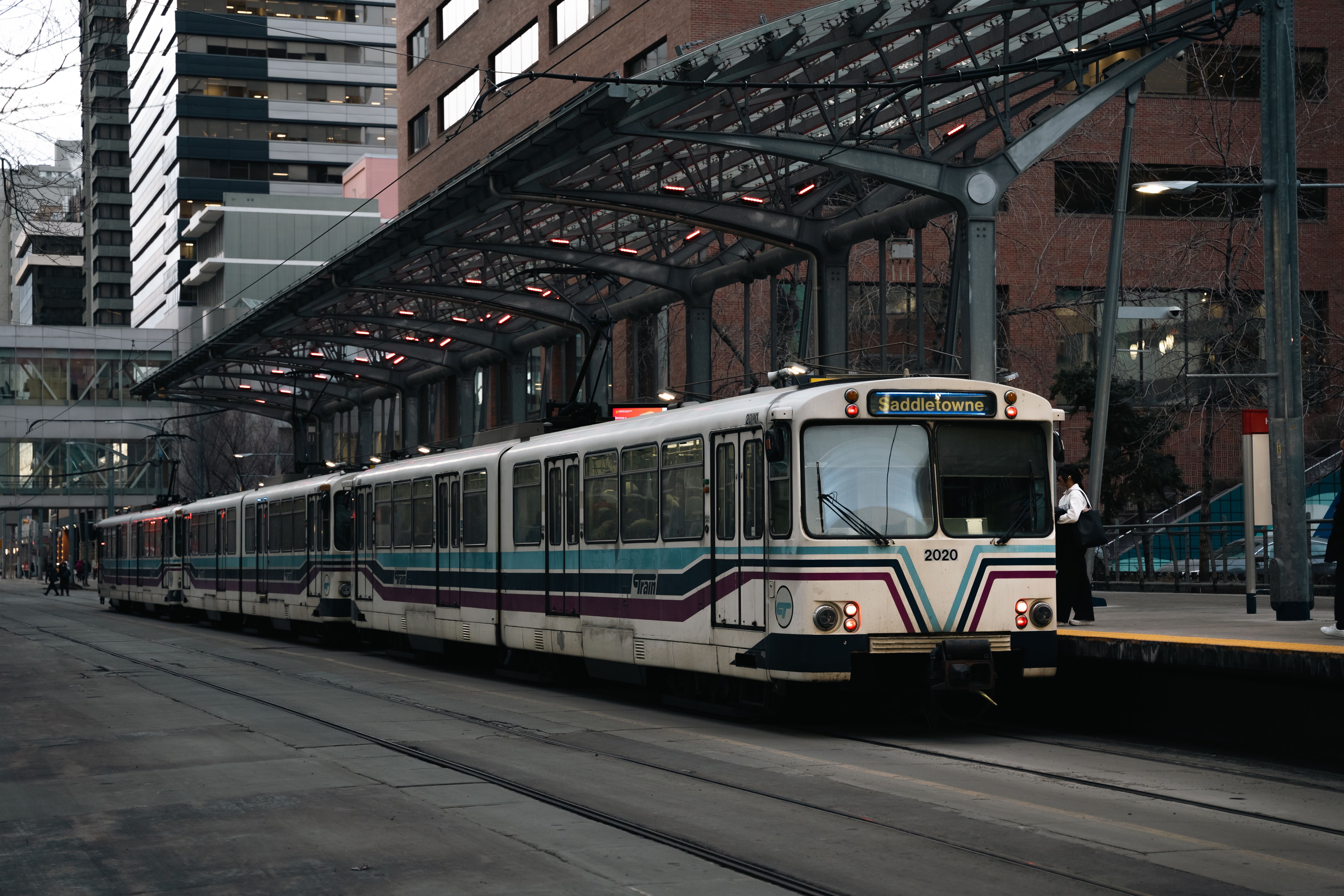Light rail train at city station with modern urban background during the day.