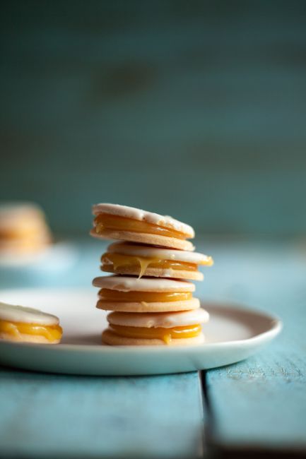A stack of Argentinian alfajores on a plate, highlighting creamy filling and soft cookies.