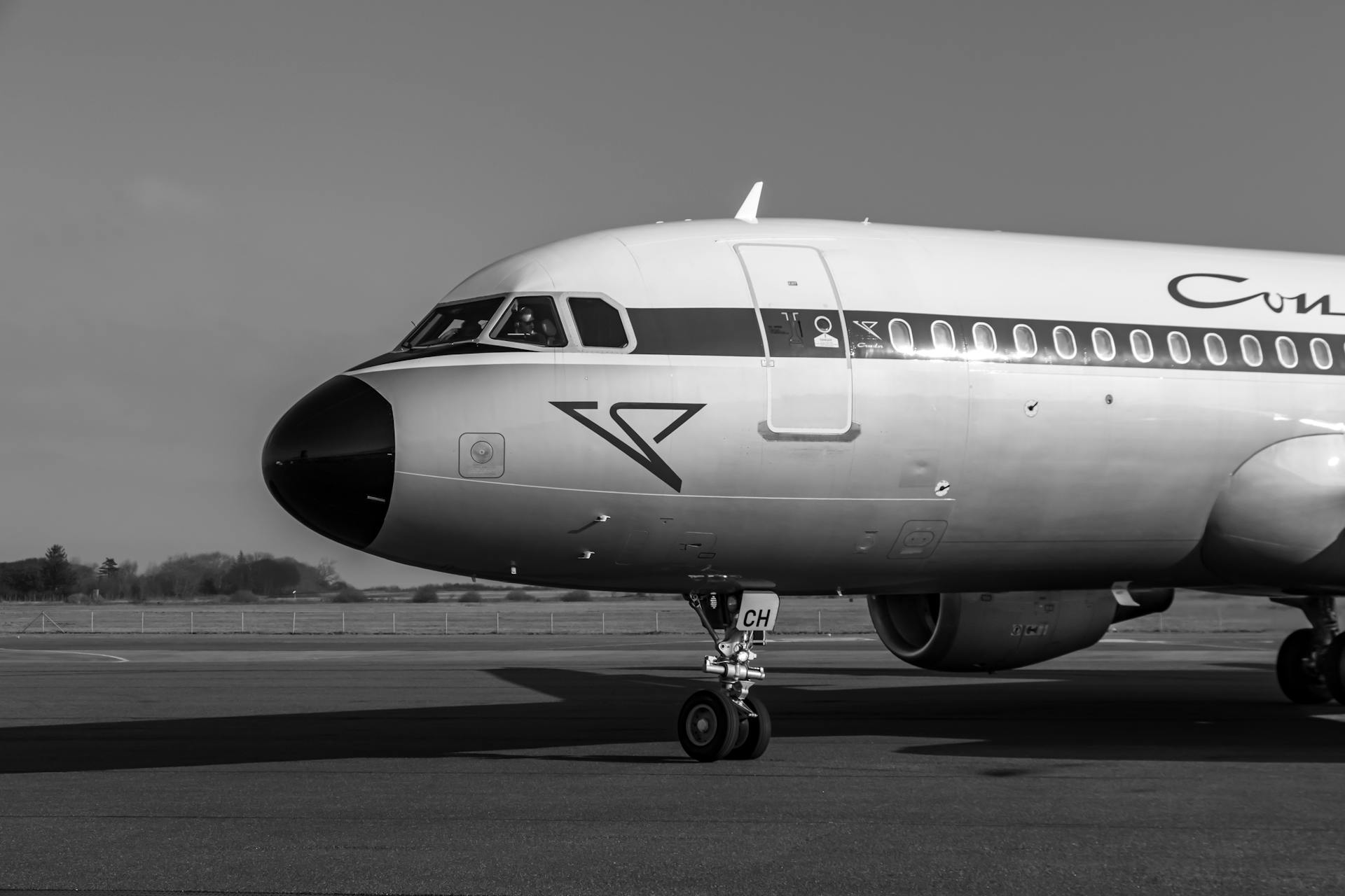 Black and white image of a commercial airplane on the runway, showcasing aviation details.
