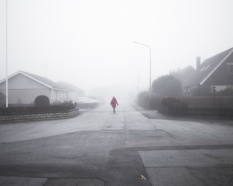 Person Walking On Street On A Foggy Day
