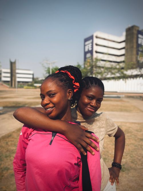 Free Smiling young women enjoying a sunny day at Obafemi Awolowo University campus. Stock Photo