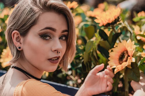 Portrait Photo of Woman Posing by Sunflowers