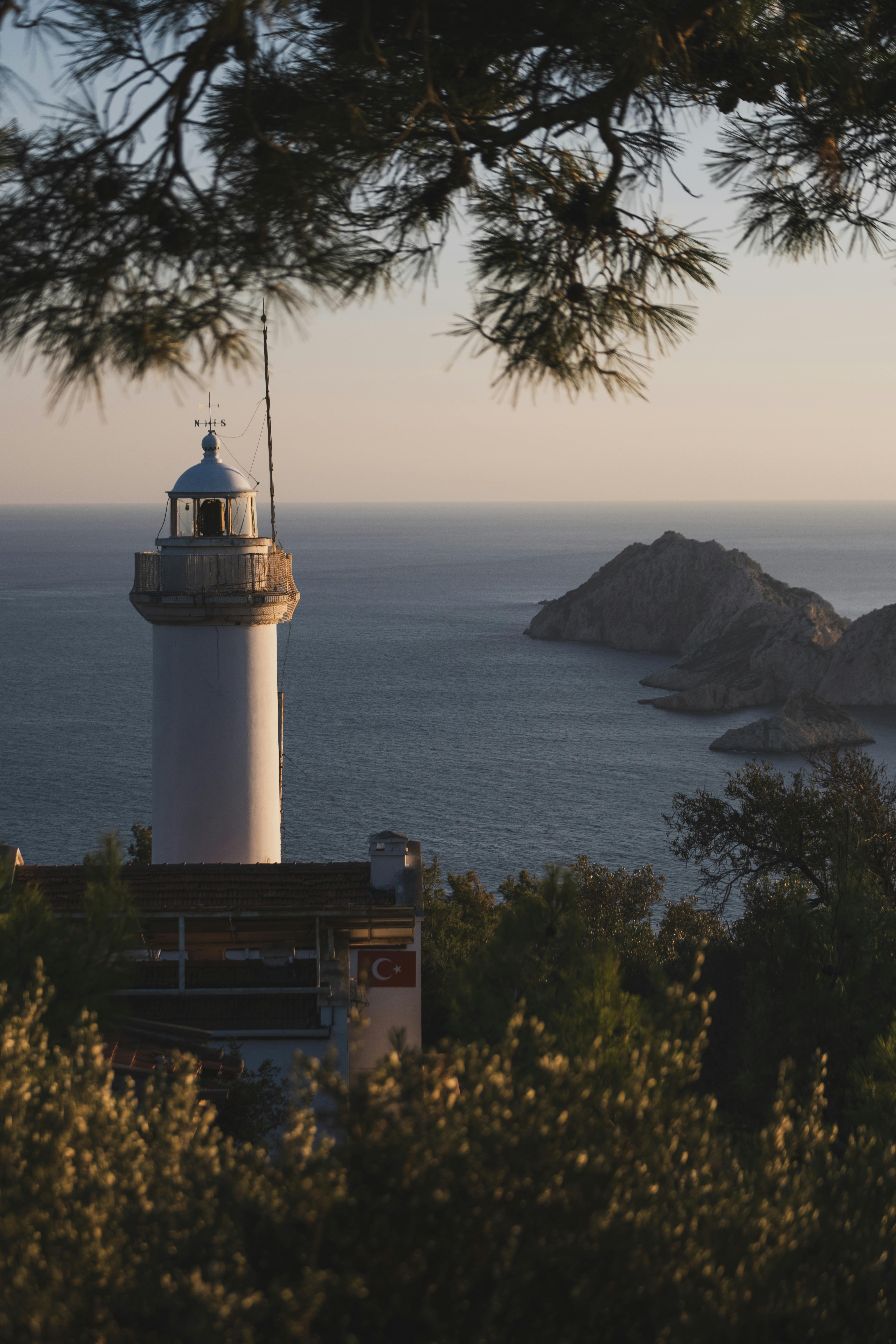 Beautiful lighthouse with scenic Mediterranean sea view during sunset.