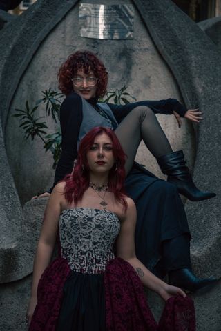 Two women in intricate period dresses on a stone backdrop — Eyüpcan Timur on Pexels