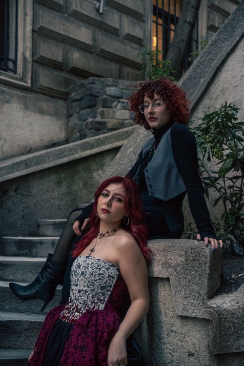 Free Two individuals in gothic style pose on a city stairway. Urban and mysterious. Stock Photo