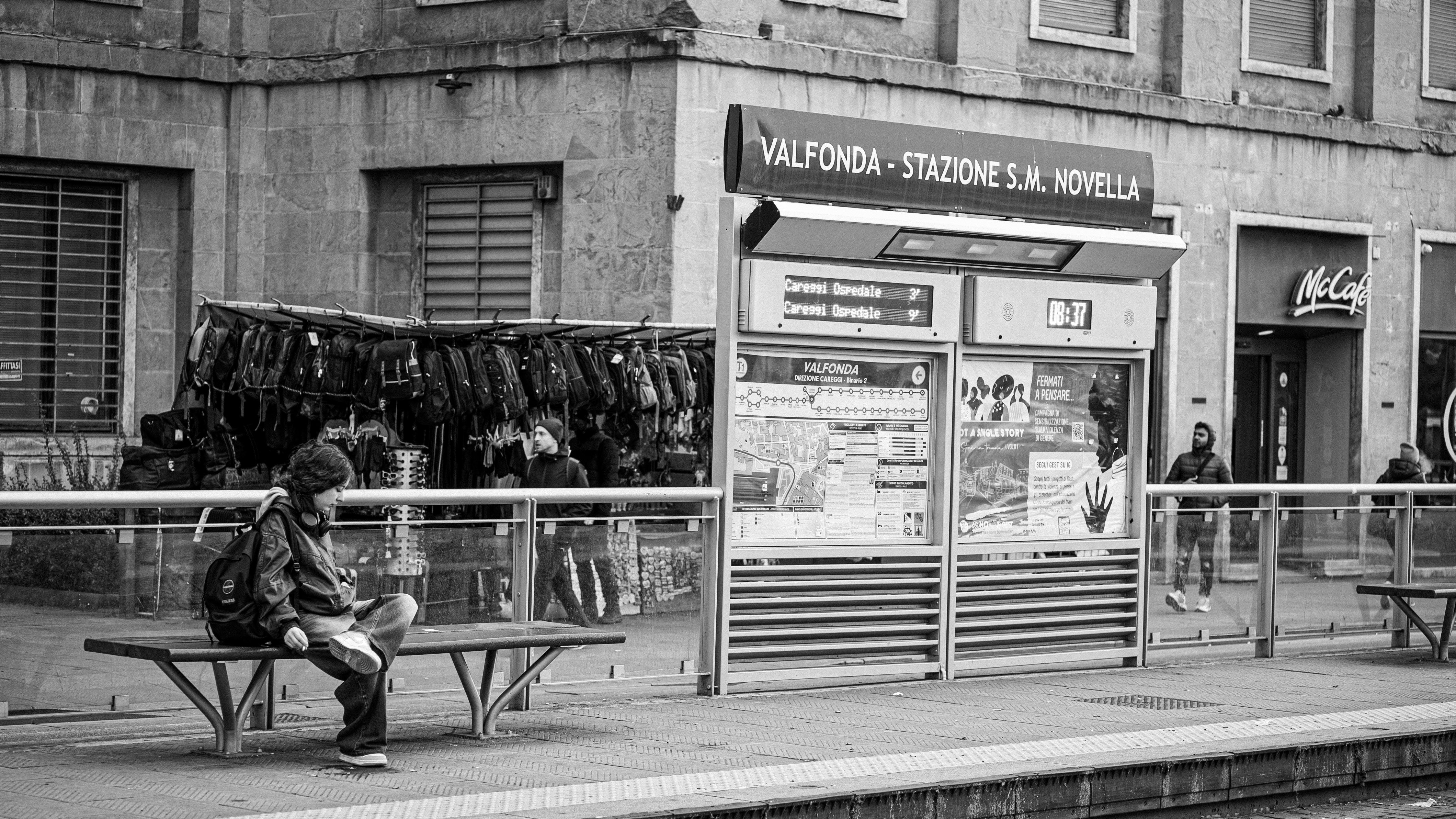 Black and white photo of Florence train station with people and luggage.