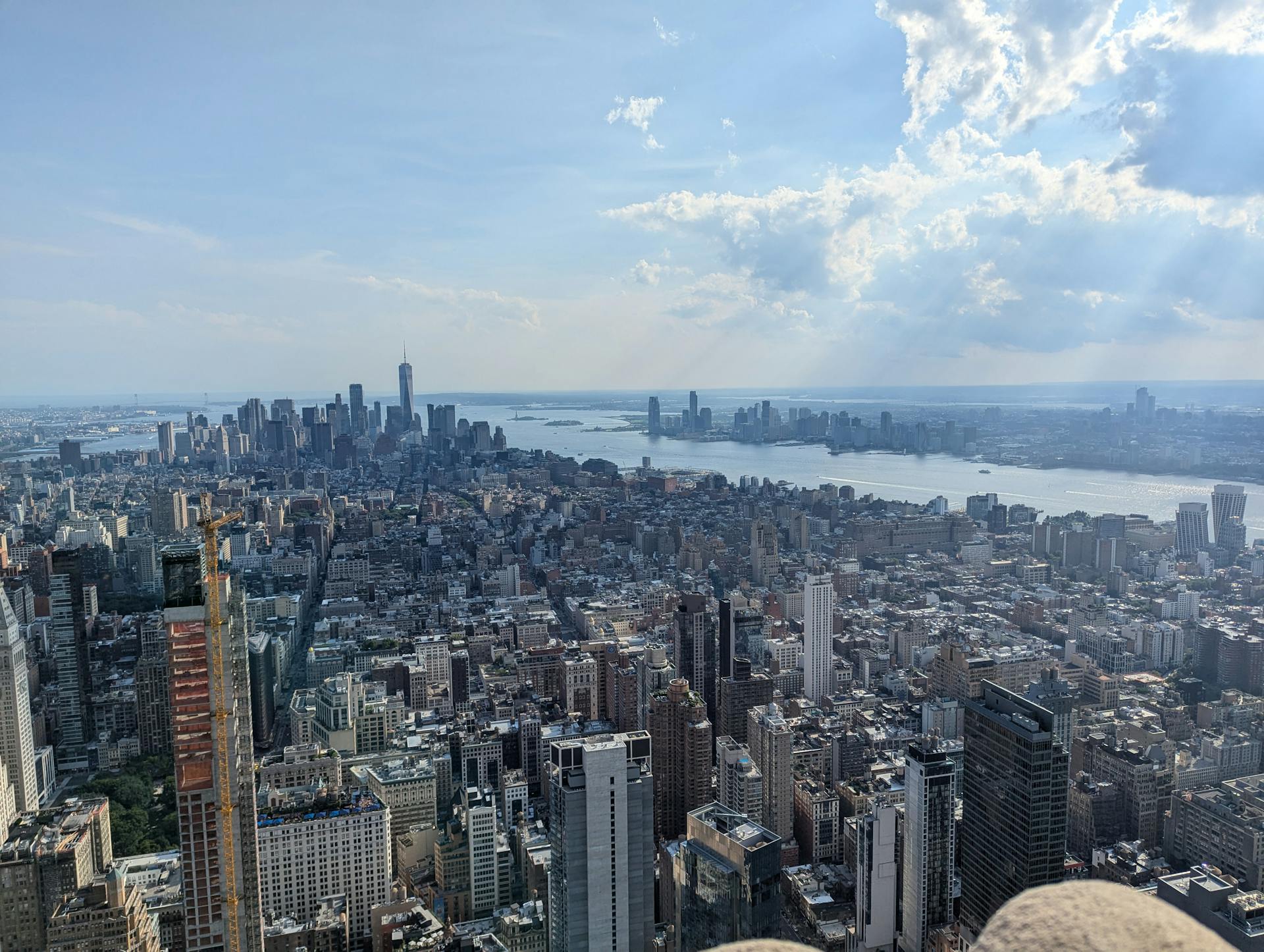 Stunning aerial view of Manhattan's skyline with the Hudson River in the background, captured on a sunny day.