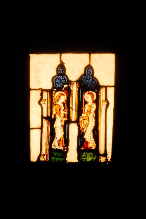 Free A vibrant stained glass window depicting religious figures in a historical setting. Stock Photo