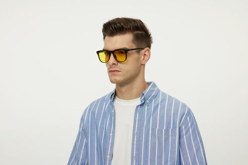 Free Portrait of a fashionable male model in sunglasses and a striped shirt. Stock Photo