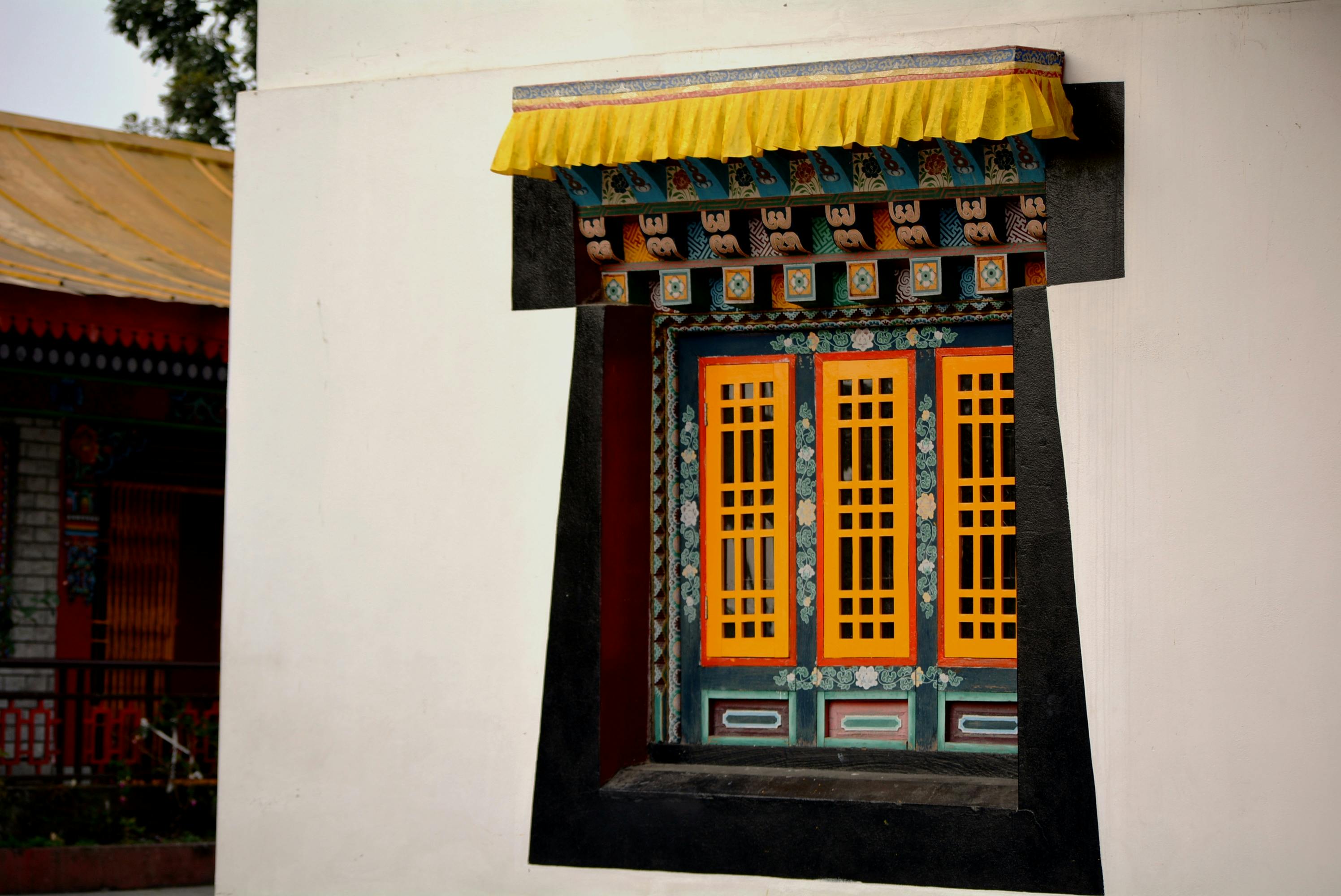 Colorful traditional Buddhist window in Gangtok, Sikkim, showcasing intricate architecture.