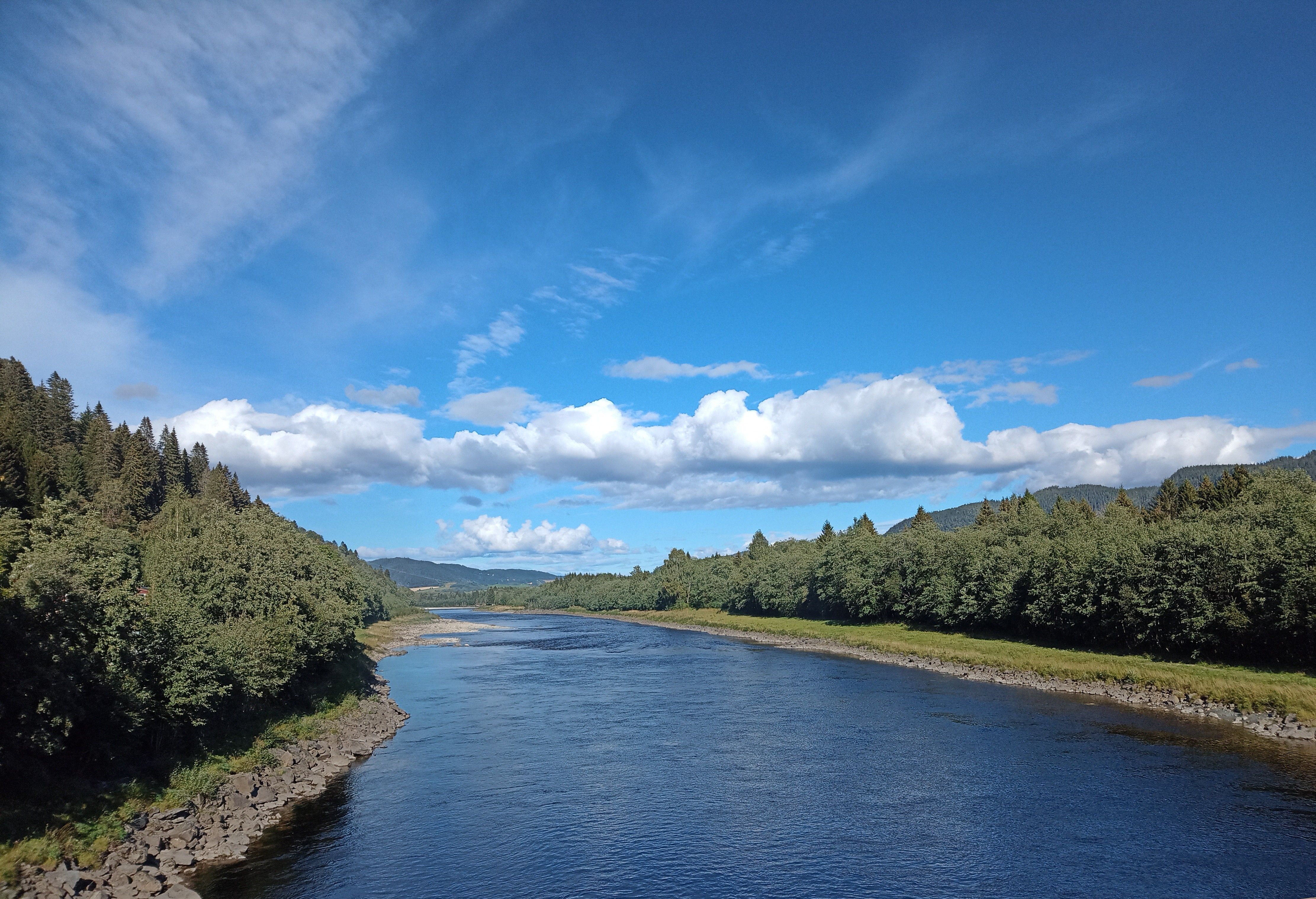 Serene River Landscape Under Blue Sky · Free Stock Photo