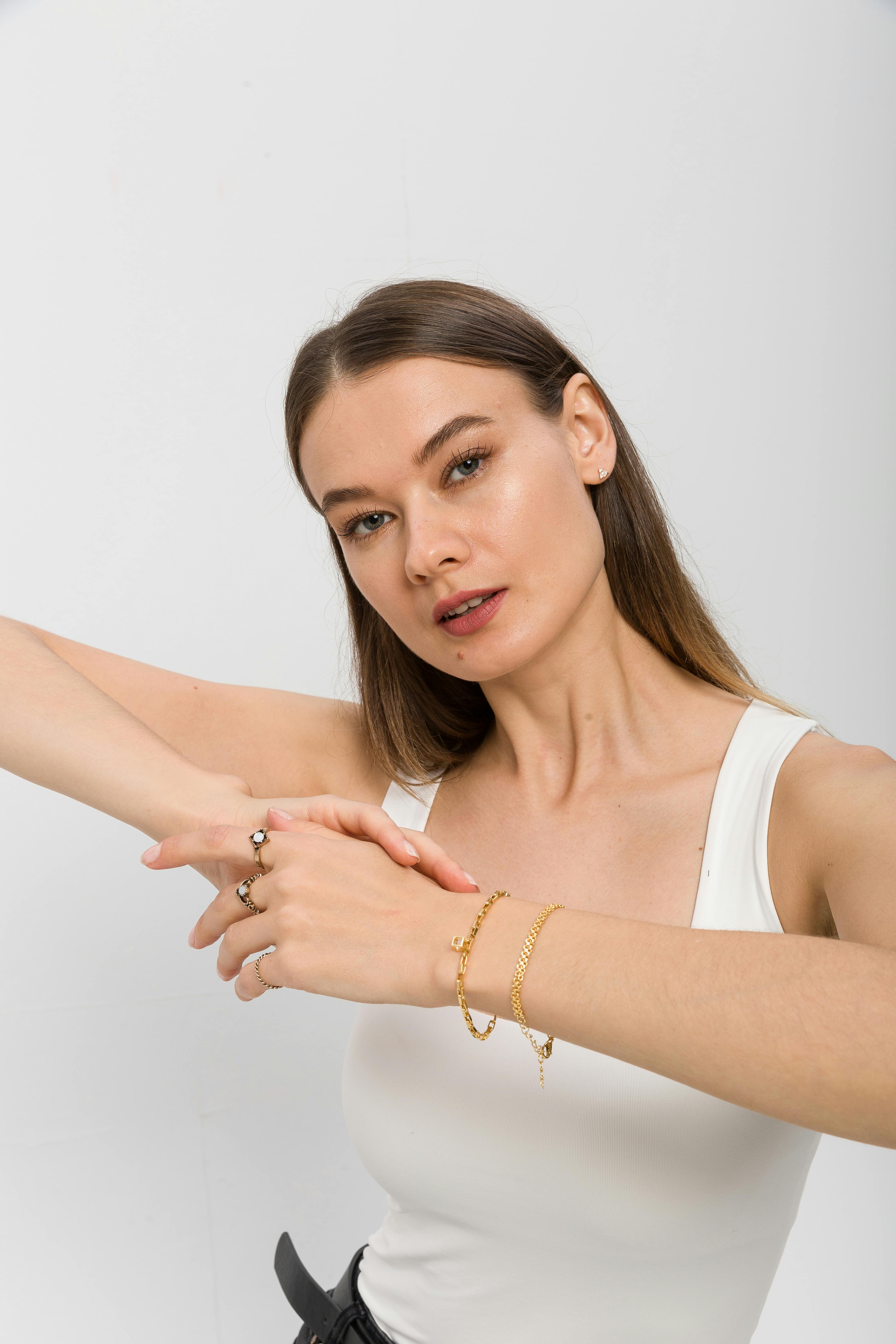 bezplatná Model předvádějící elegantní zlaté šperky a doplňky v prostředí studiového portrétu. Základová fotografie