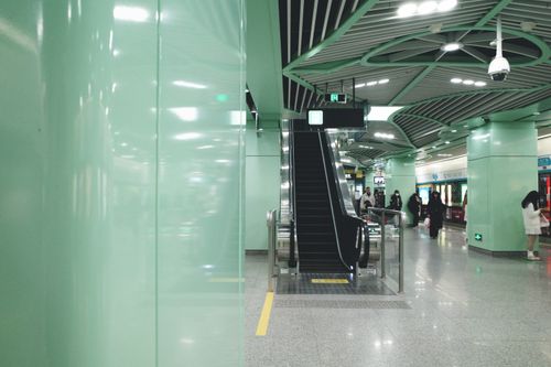 Free Spacious modern subway station featuring an escalator and people, highlighting urban transit design. Stock Photo