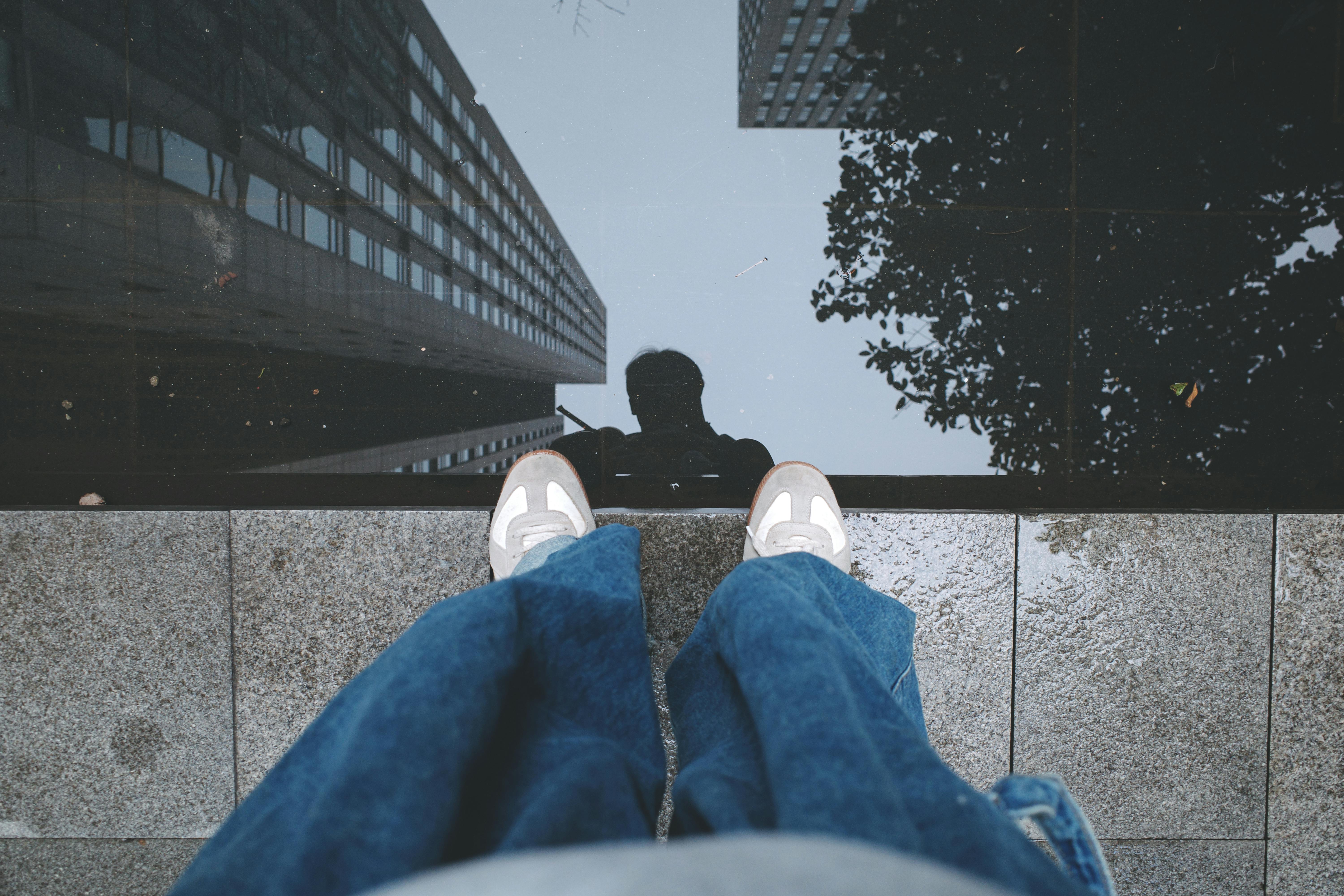 Person reflected in water with buildings, adding an urban touch.