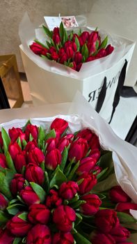 A lush bouquet of red tulips beautifully arranged in a white gift box, perfect for any occasion.