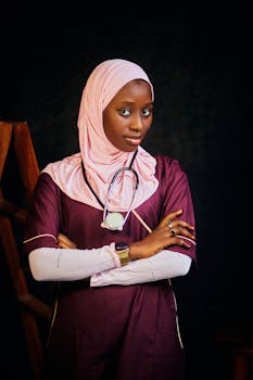 Young nurse wearing a hijab with a stethoscope, standing confidently in medical attire.