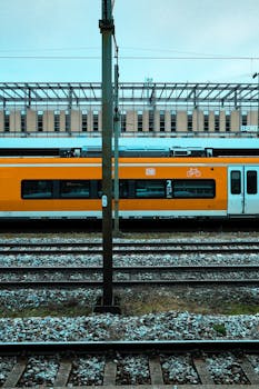 A vibrant orange train at Munich station, showcasing modern German transport.