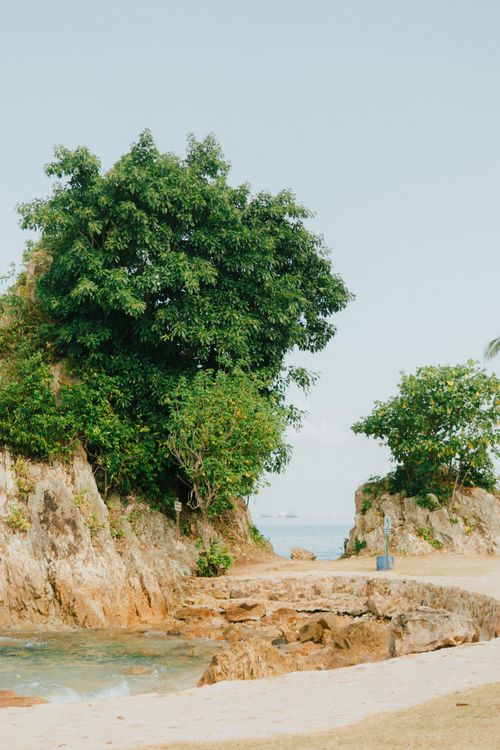 Free Explore the stunning rocky coast and lush greenery of Lampung's vibrant beach landscape. Stock Photo