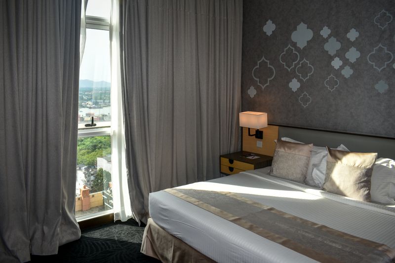Cozy modern hotel room with large window and mountain view, perfect for travelers.