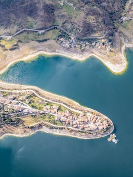 Stunning aerial view of Colle di Tora, Lazio, Italy, showcasing a serene peninsula surrounded by azure waters.