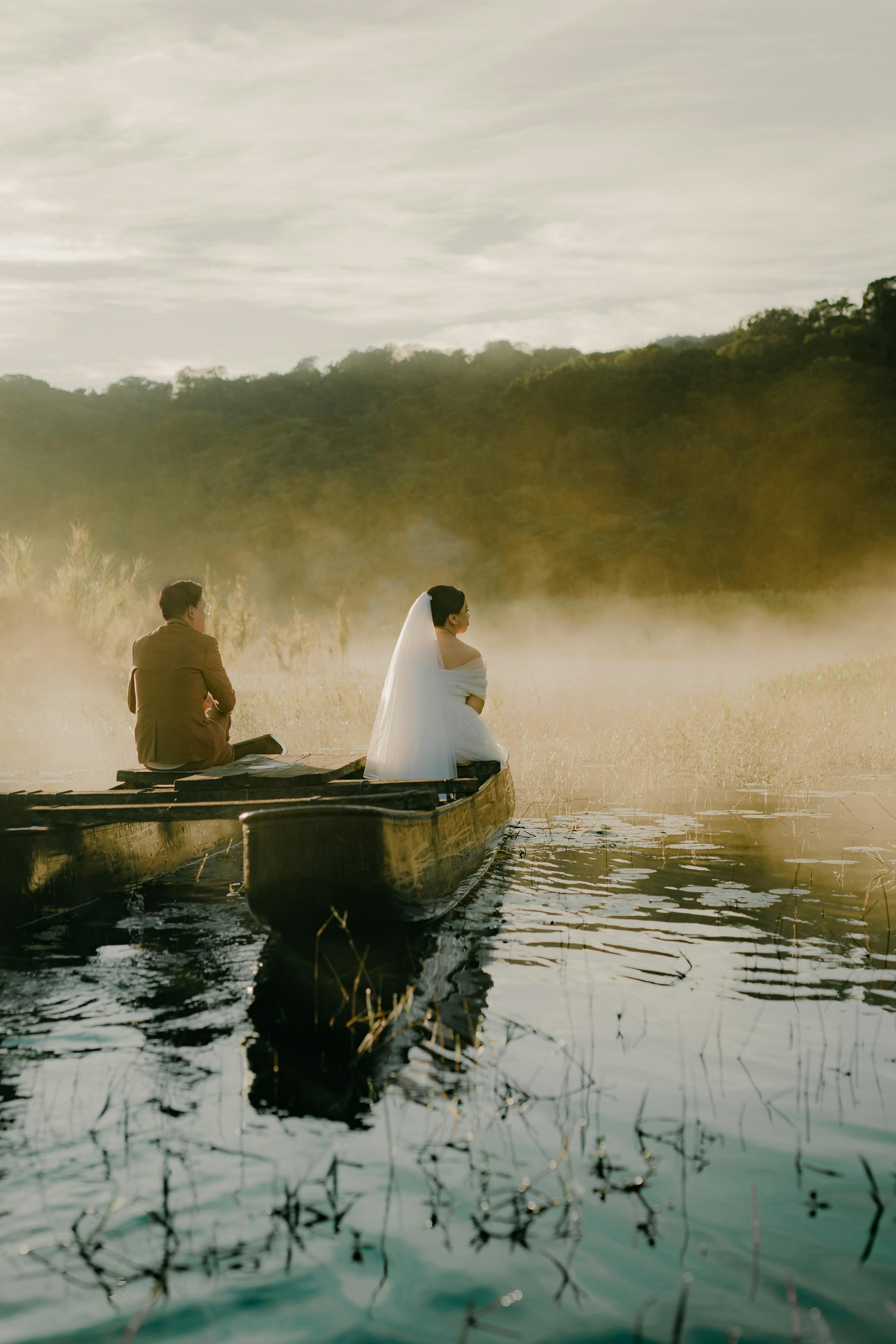 A romantic couple poses for their prewedding photoshoot on a misty Indonesian lake.