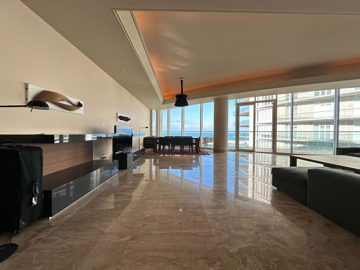Panoramic coastal living room with minimal furniture and sea views