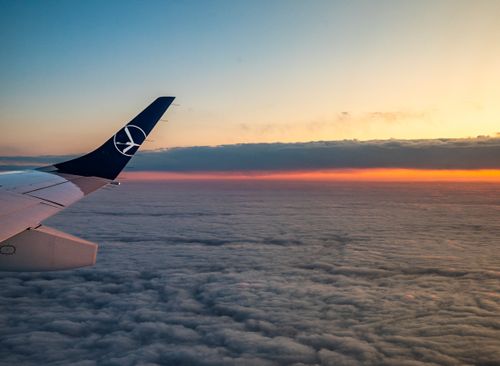 Free A tranquil airplane view of a vibrant sunset over clouds, capturing the essence of travel and serenity. Stock Photo