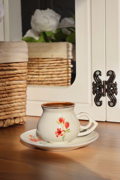 Free Elegant porcelain teacup on wooden table with floral accents and wicker decor. Stock Photo