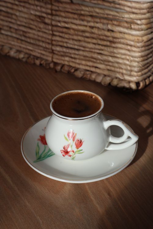 Free A cup of Turkish coffee served in a floral porcelain cup on a sunny wooden table. Stock Photo
