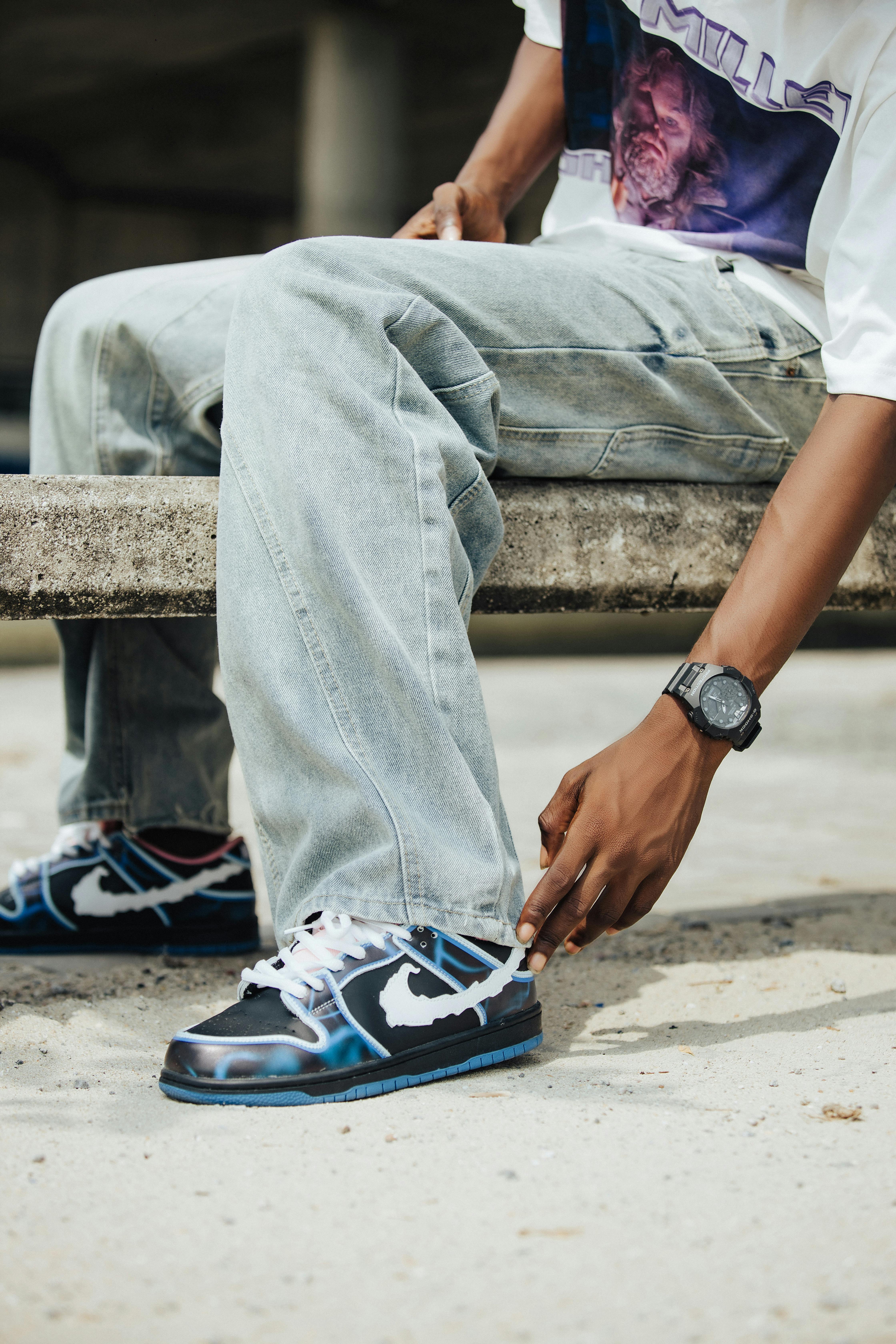 Urban street style featuring casual denim jeans, patterned sneakers, and trendy accessories.