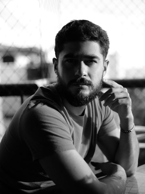 Free Moody black and white portrait of a bearded man sitting indoors, captured with natural light. Stock Photo