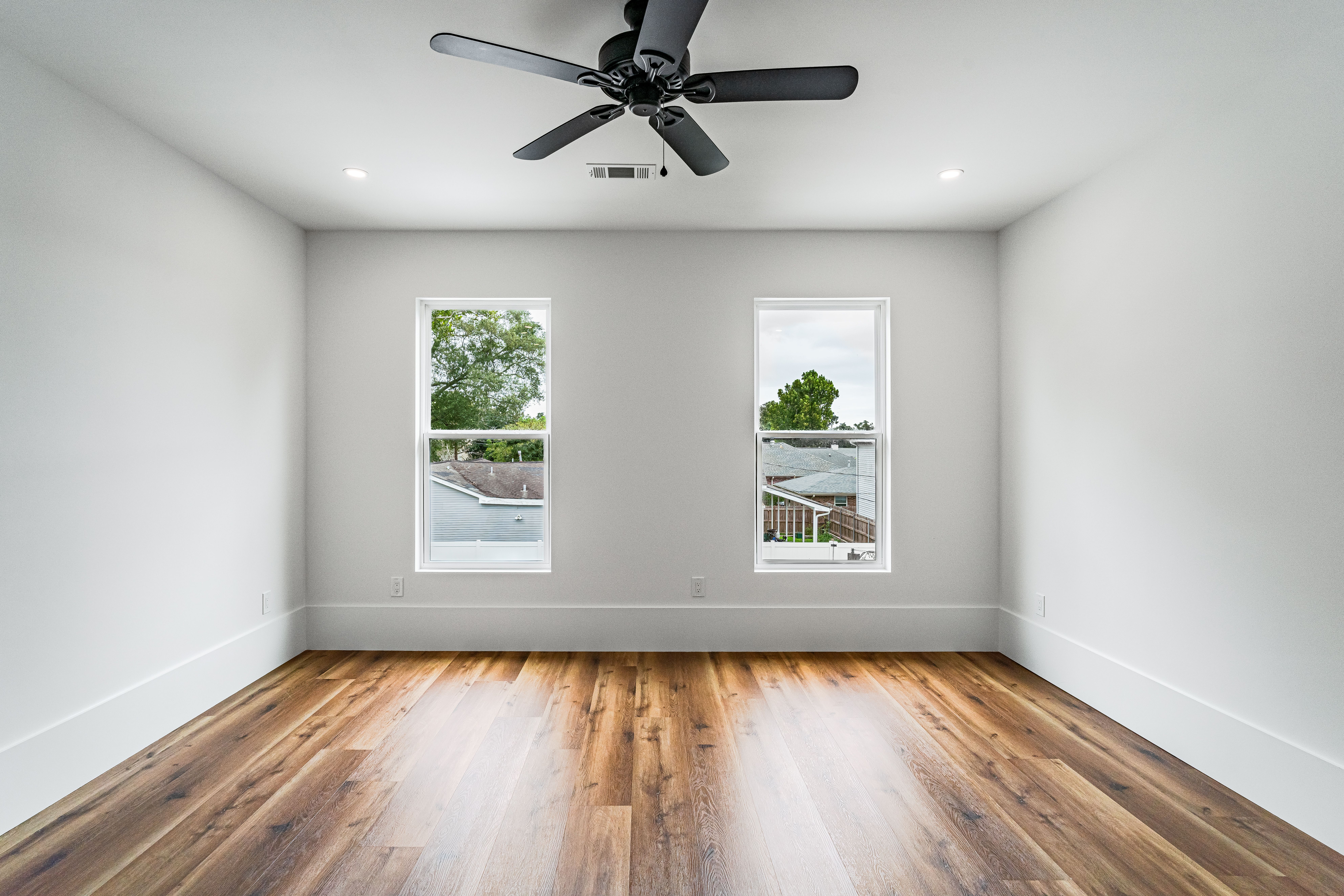 Quarto claro com cama, janela e ventilador de teto