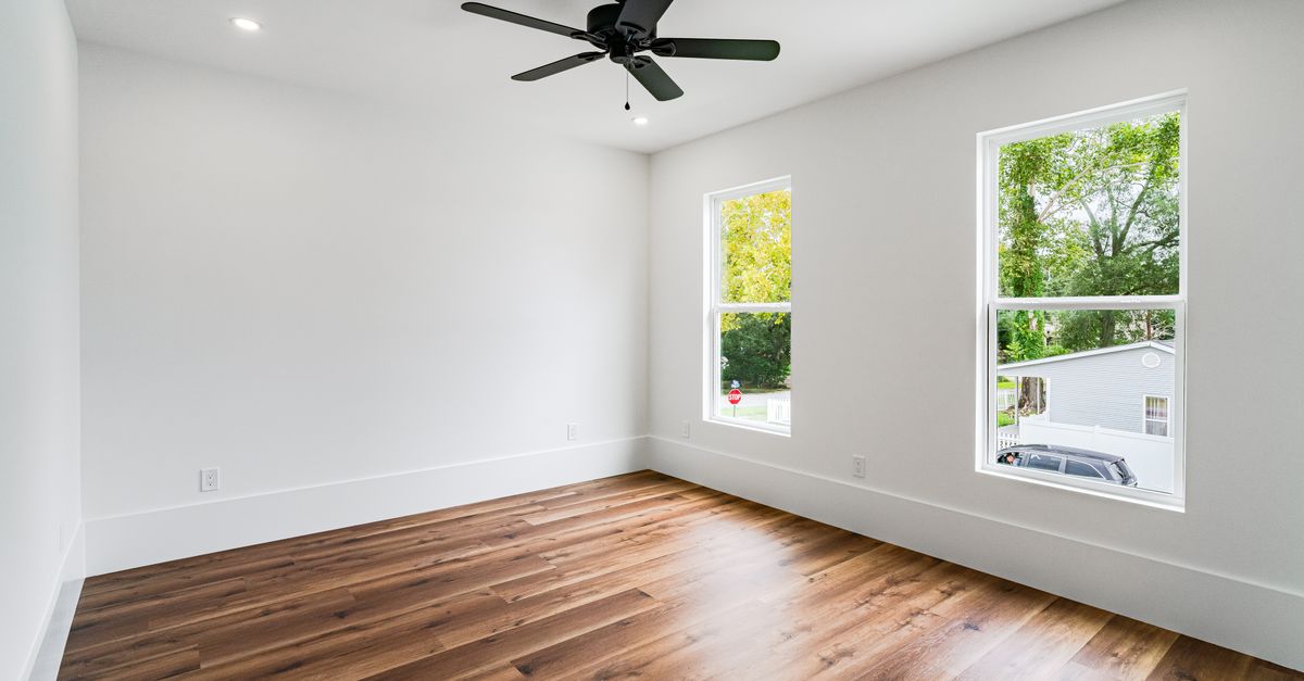 Empty room with wooden floors and ceiling fan in a New Orleans home, perfect for real estate listings.