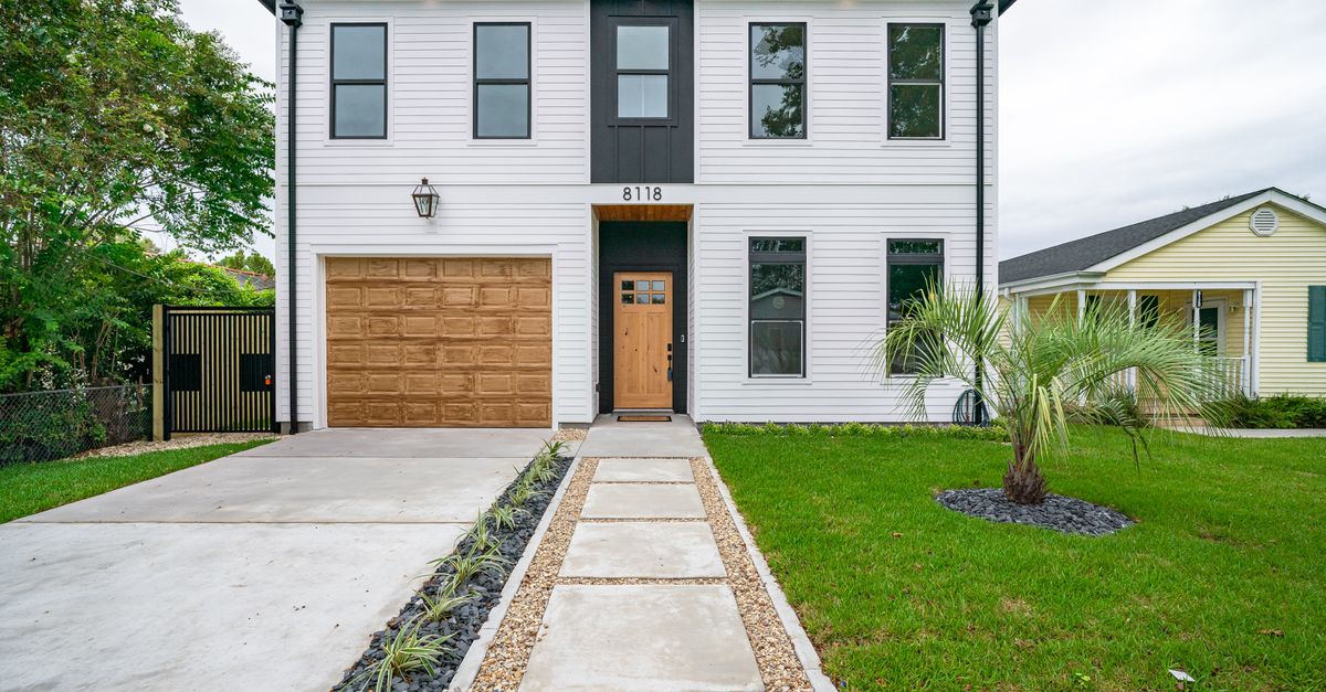 Sleek modern home in New Orleans featuring minimalist architecture and lush landscaping.